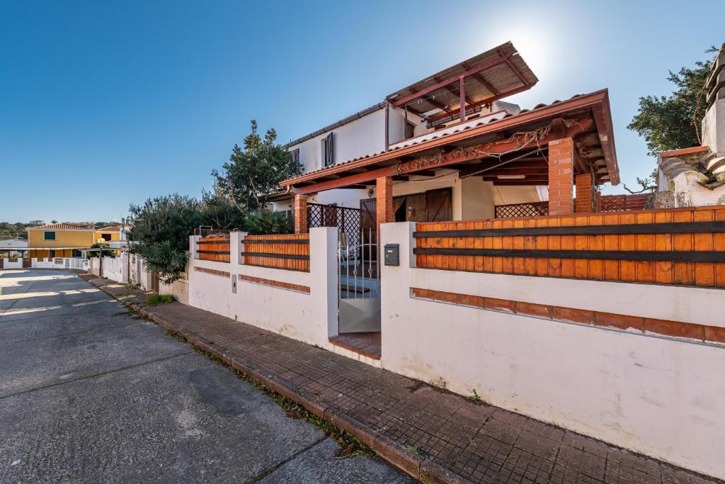 une maison avec une clôture et un portail dans une rue dans l'établissement Via Delle Mimose 14, à Calasetta