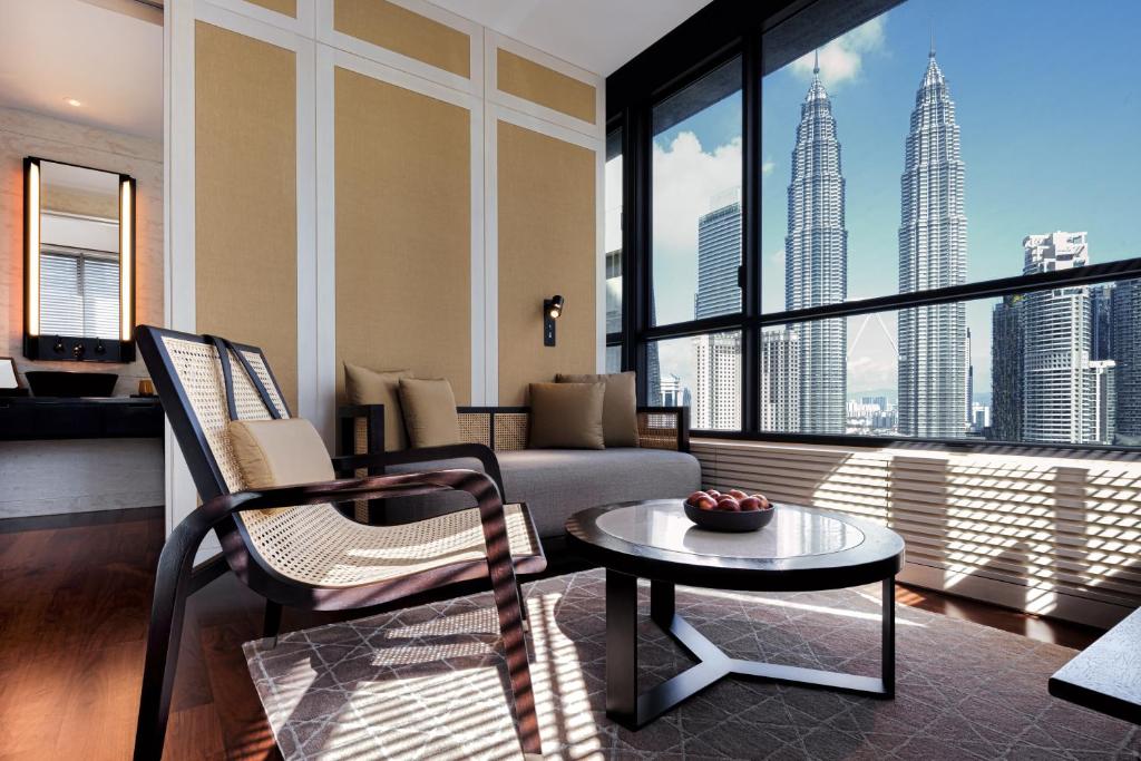 A bright sitting room with lounge seating and a direct Petronas Towers view.