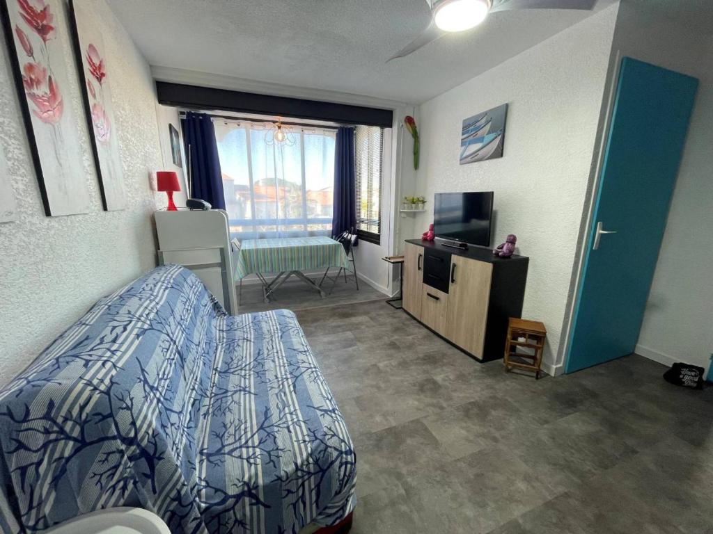 une chambre avec un lit et une télévision dans l'établissement Charmant 2P, 2 couchages, parking, loggia, proche plage et centre, animaux acceptés - FR-1-225D-171, à Saint-Cyprien