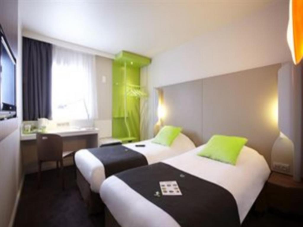 a hotel room with two beds with green accents at Campanile Auxerre - Monéteau in Monéteau