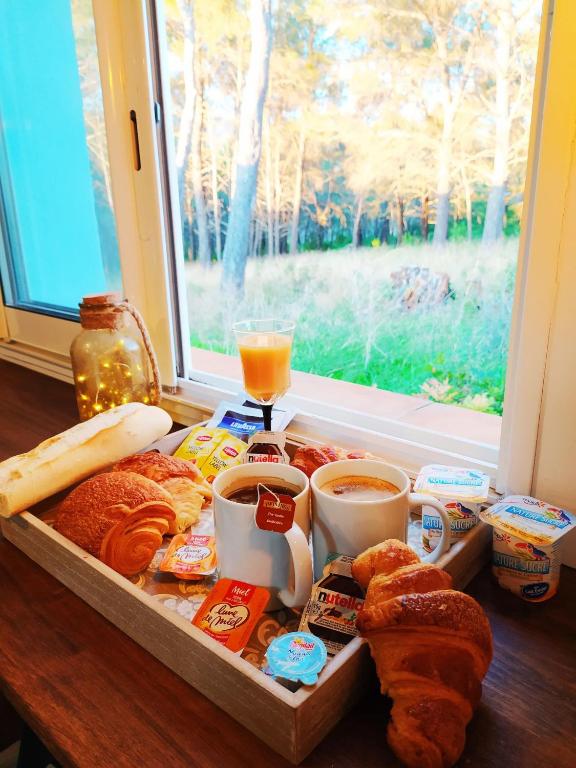 a tray of bread and coffee and a window at A l&#39;Orée des pins - Gite indépendant avec baignoire balnéo et Home Cinéma en sup - Voir info de l&#39;hôte in Cuges-les-Pins