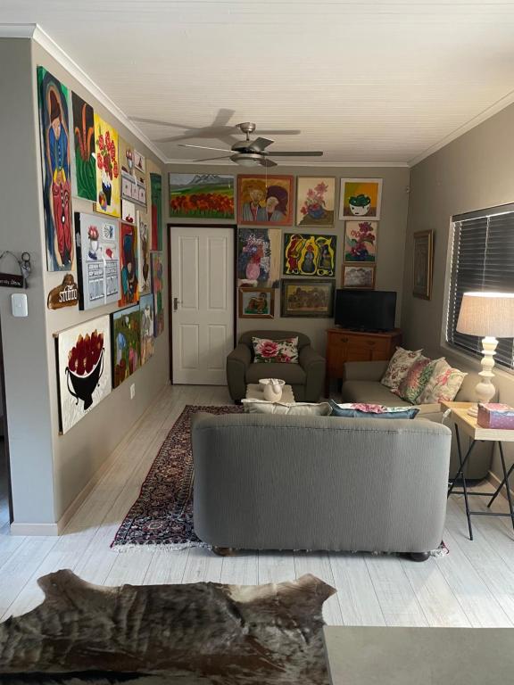 a living room with a couch and paintings on the walls at The Studio in Colchester