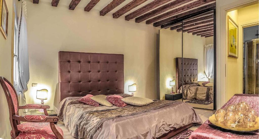 una camera con un grande letto e uno specchio di Venice Dream House a Venezia