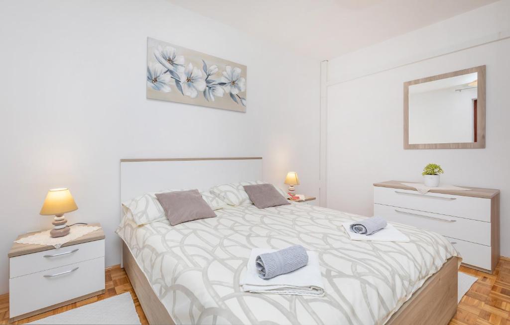 a white bedroom with a large bed and a mirror at Rooms Ivo in Dubrovnik