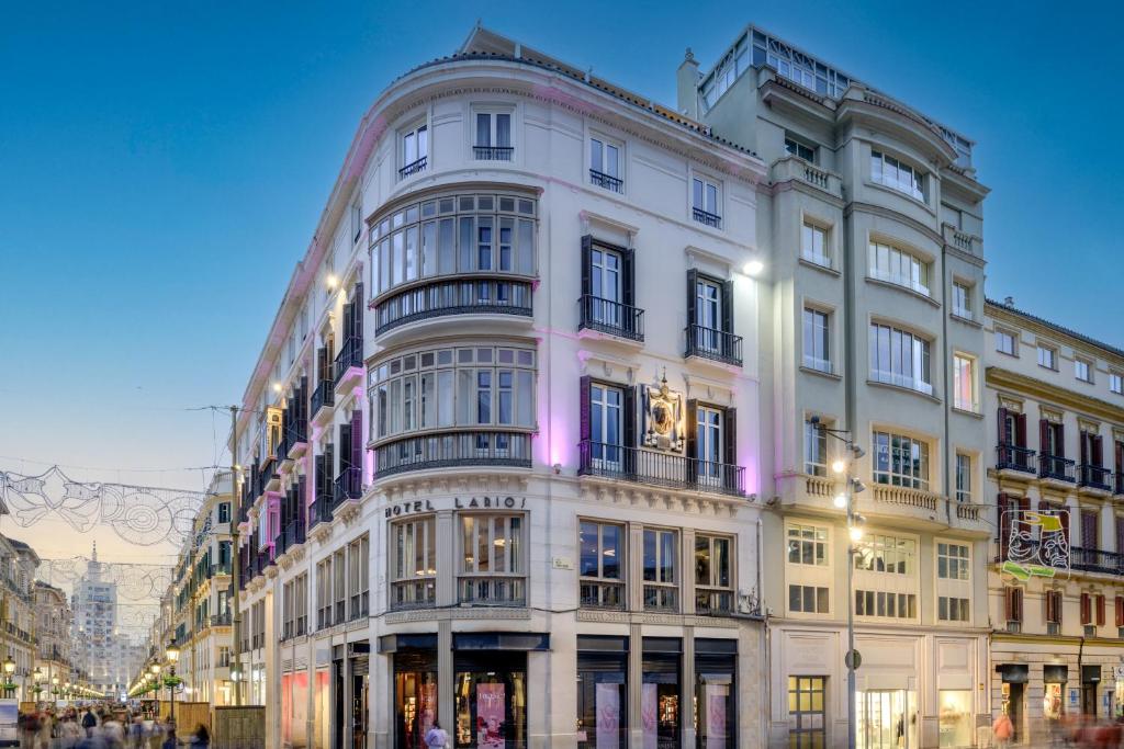 a large white building on the corner of a street at Hotel Larios Málaga in Málaga