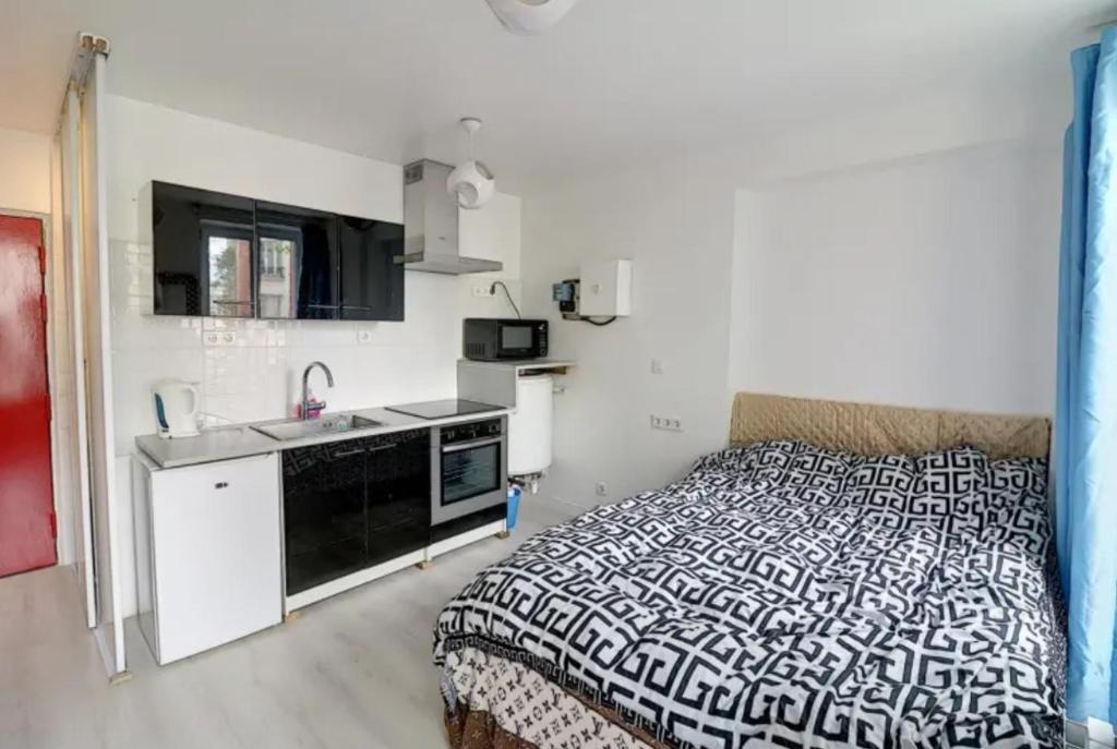 ein kleines Schlafzimmer mit einem Bett und einem Waschbecken in der Unterkunft studio paris cardinet in Paris