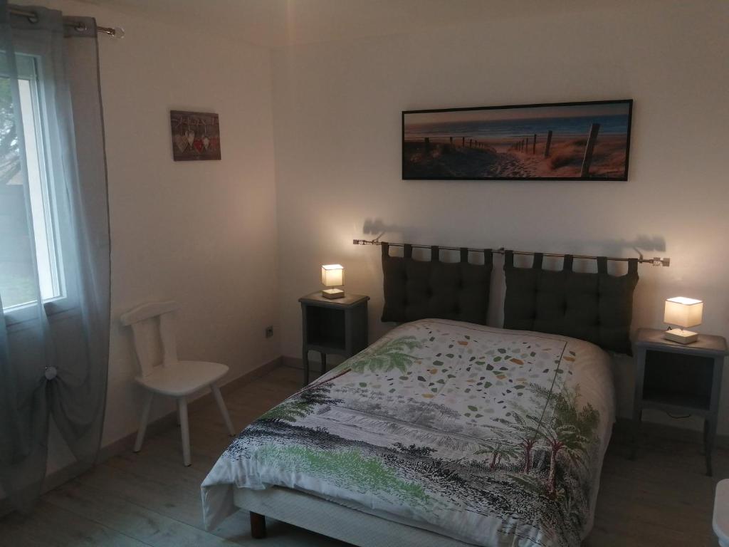 1 dormitorio con 1 cama y 2 luces en 2 mesas en gite repos et tranquillité M, en Cayeux-sur-Mer