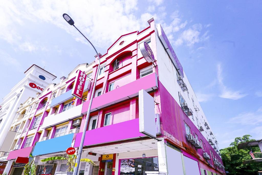 a pink and white building on a city street at OYO 90486 New Station Hotel in Klang