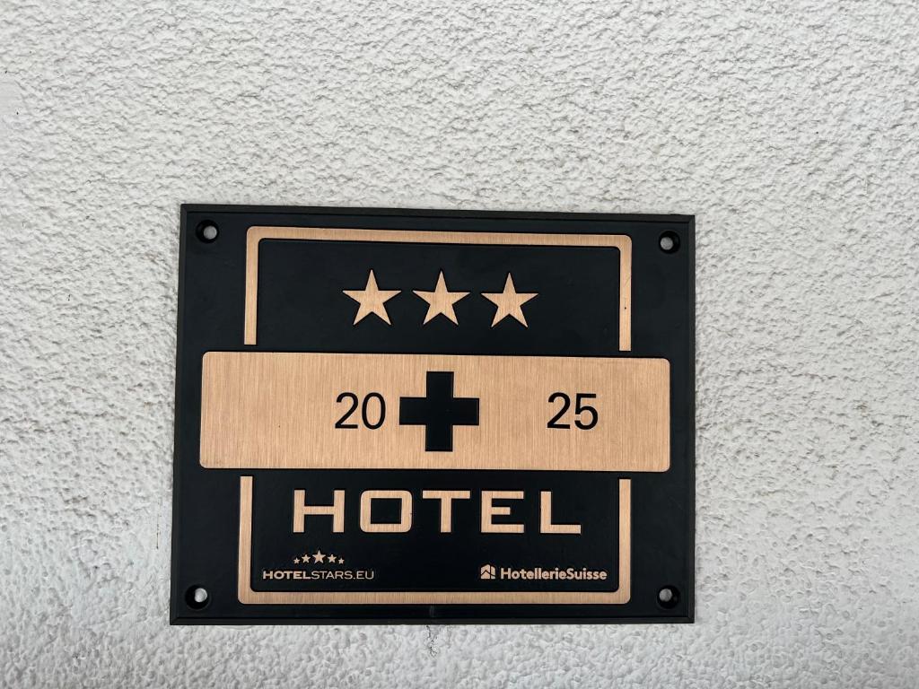 a sign for a hotel hanging on a wall at Hotel Fassbind Beausite in Beatenberg