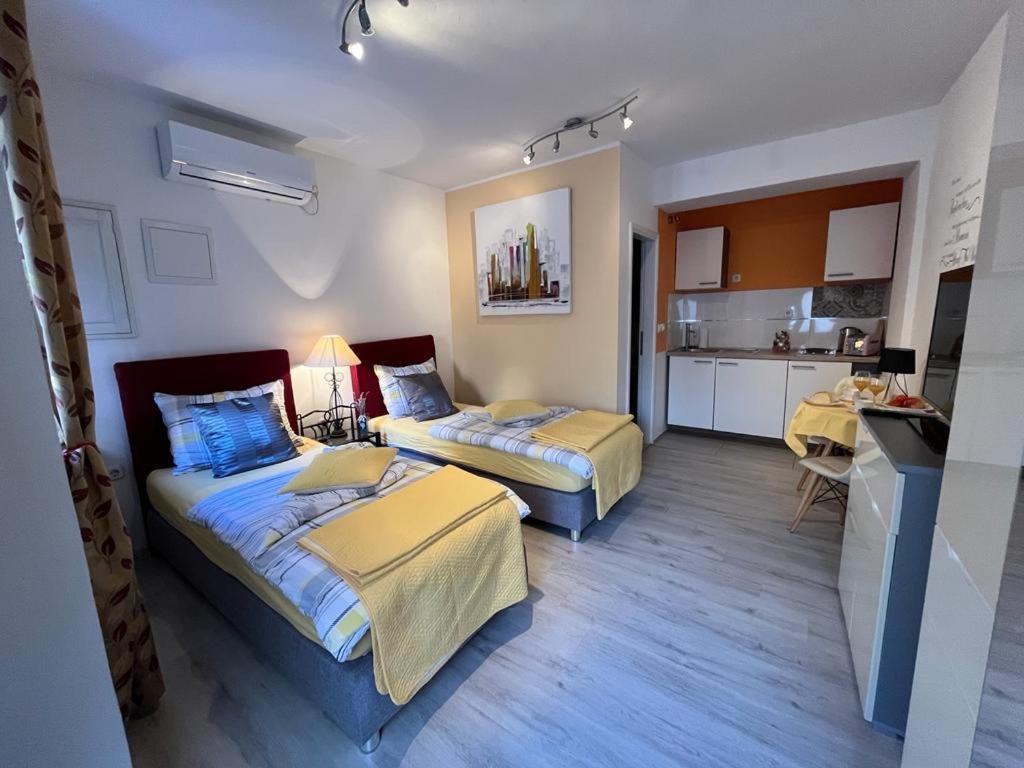 um quarto de hotel com duas camas e uma cozinha em Titius Apartment em Skradin