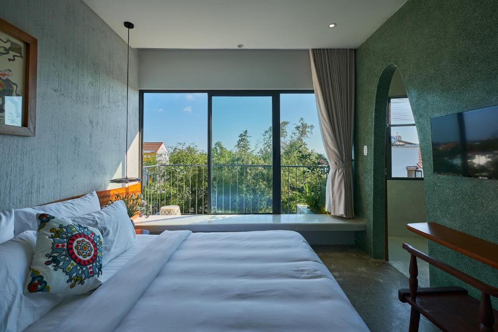 une chambre avec un grand lit et un balcon dans l'établissement Barbados Cherry Villa, à Hội An