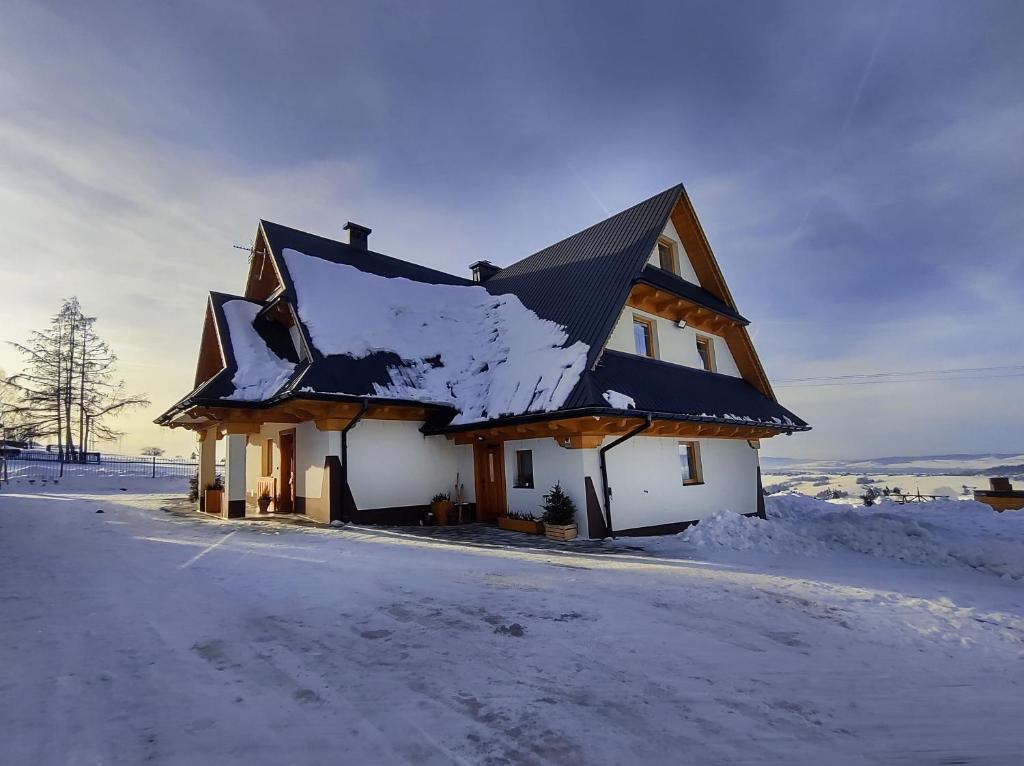 Bańska WyżnaApartamenty Za Wierchem的屋顶上积雪的房子