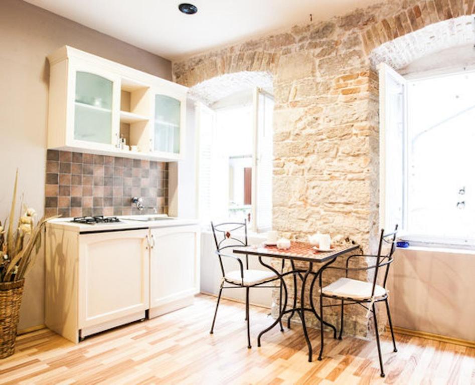 a kitchen with a table and chairs in a room at Zara City Apartments in Zadar