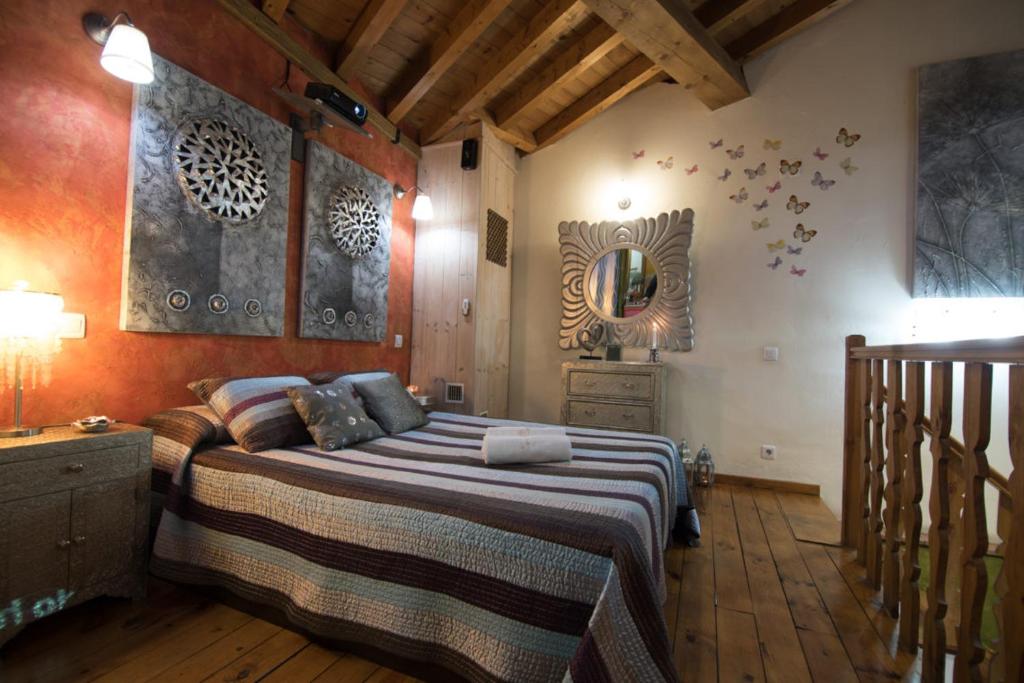 a bedroom with a large bed and a mirror at El Balconcillo-Los Sitios de Aravalle in Umbrías