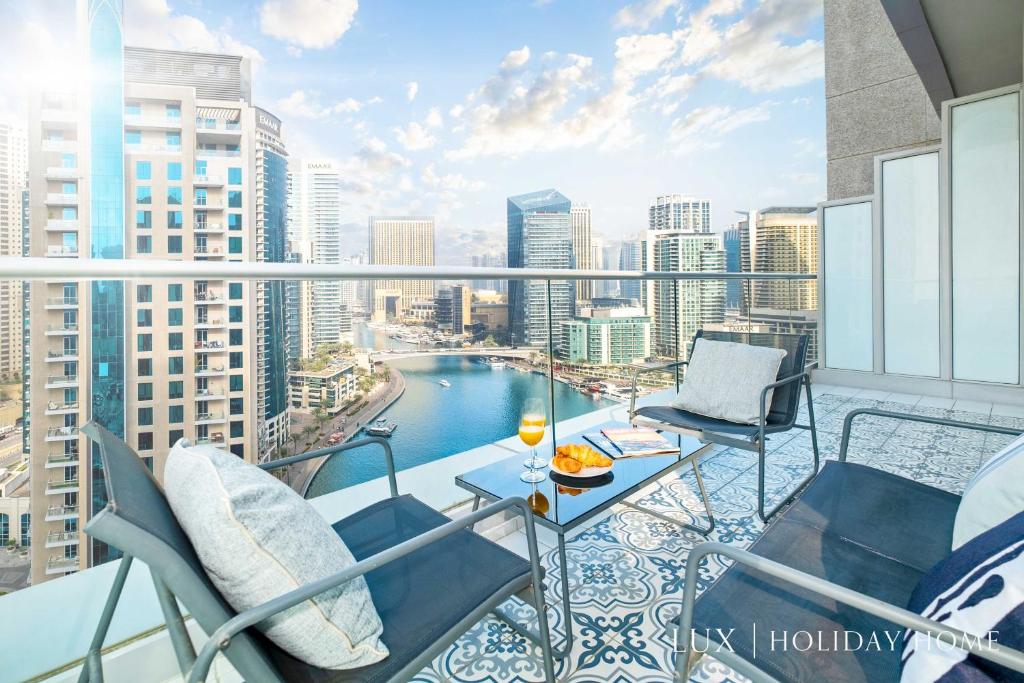 - Balcón con mesa y sillas en un edificio en LUX Marina Promenade Penthouse Suite, en Dubái