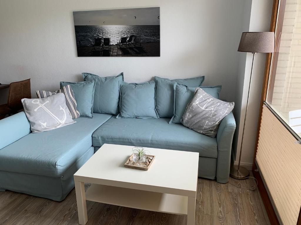 Sofá azul en la sala de estar con mesa en Huus Parlbuggt, en Büsum