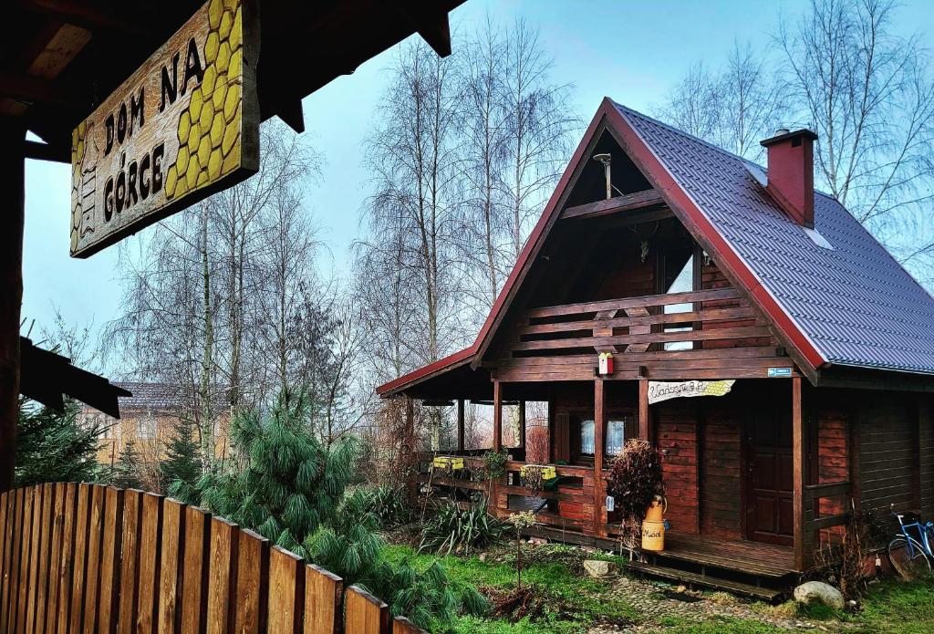 un petit bâtiment avec un panneau devant lui dans l'établissement Domki na Górce, à Wądzyn