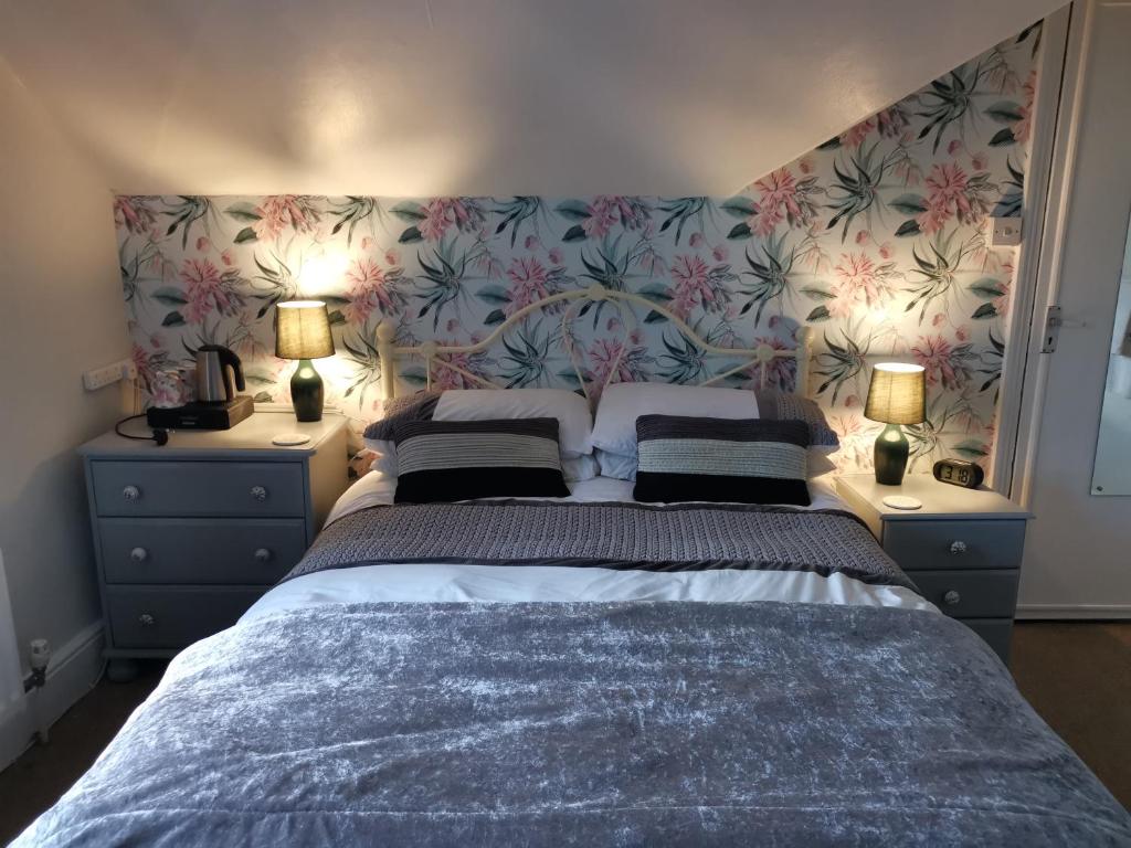 una camera da letto con un grande letto con due comodini di Brooklands Guest House a Bowness-on-Windermere