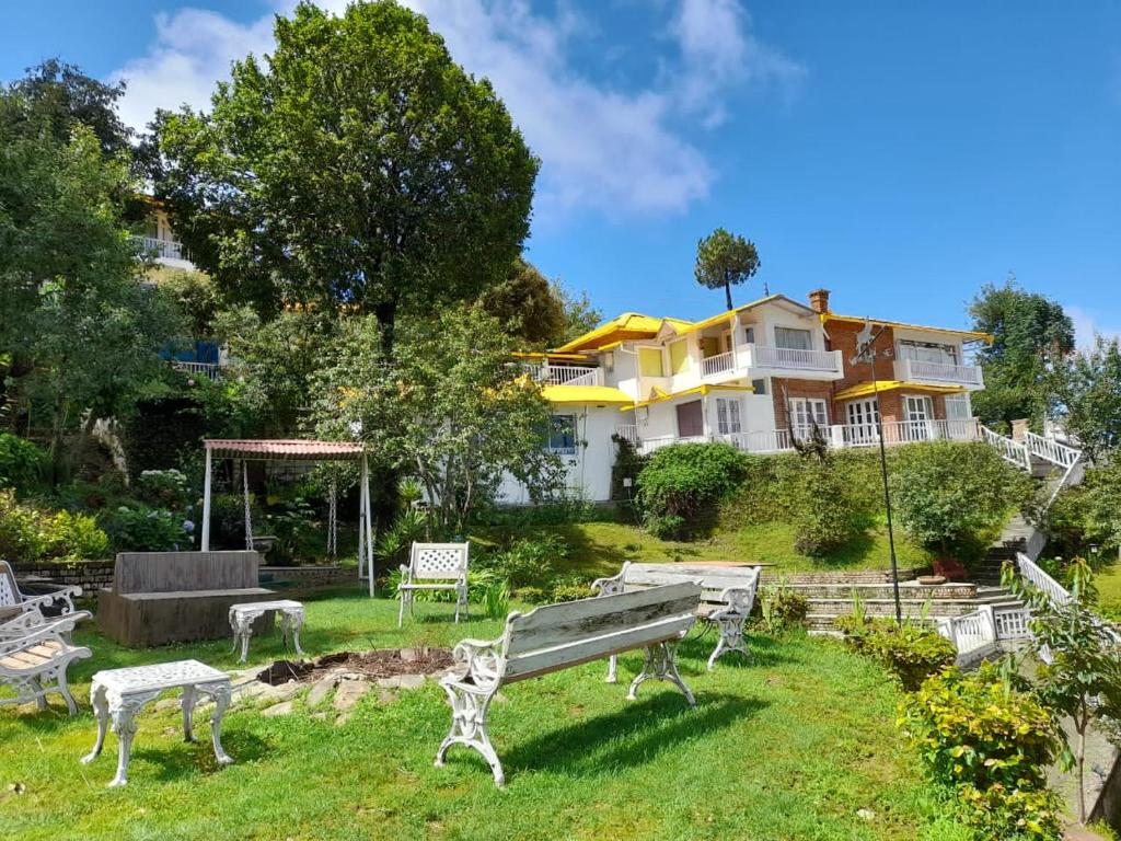 a house with a bench in the yard at Te Aroha By Shervani in Mukteswar