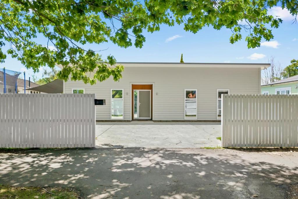 a white house with a fence in front of it at Contemporary Comfort - Masterton Holiday Home in Masterton