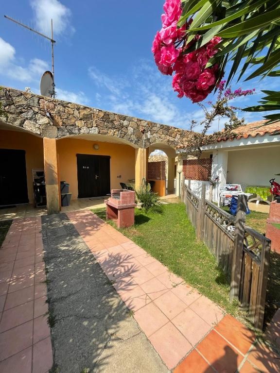 a house with a garden and a driveway at Appartamenti Spiaggia Bianca in Golfo Aranci