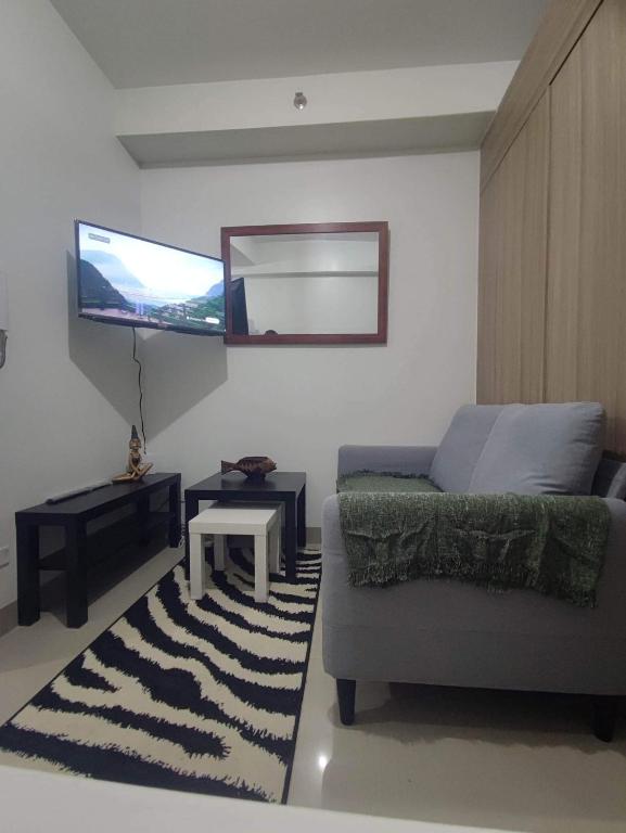 a living room with a couch and a tv at Shore 2 near MOA in Manila