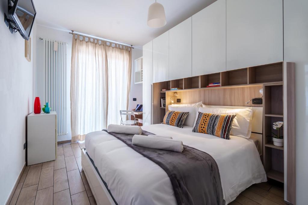 a bedroom with a large bed with white sheets at Il Nido di Sesto - Vicino a Milano in Sesto San Giovanni