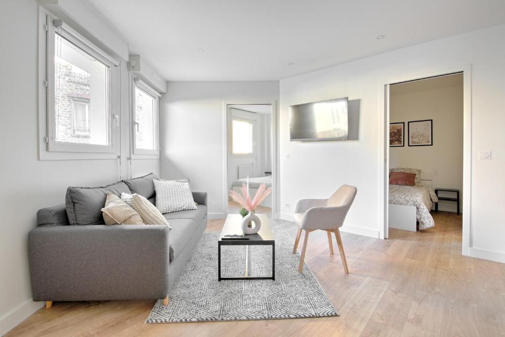 a living room with a gray couch and a chair at Le Vitry - Appt 2 Chambres à 20min Orly in Vitry-sur-Seine