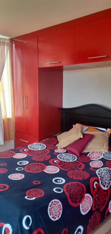 - une chambre avec un lit doté d'une tête de lit rouge dans l'établissement Casa N Campestre en las faldas del Taita Imbabura, à San Juan de Ilumán
