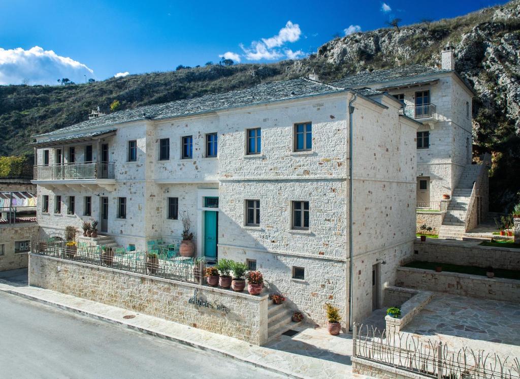 a large stone building with plants on a street at Haones Suites in Ioannina