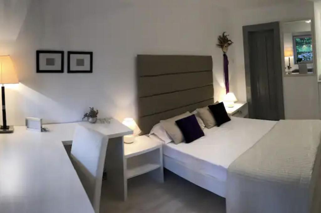 a white bedroom with a bed and a desk at studio in vila- natural 22 C ! in Breaza de Sus