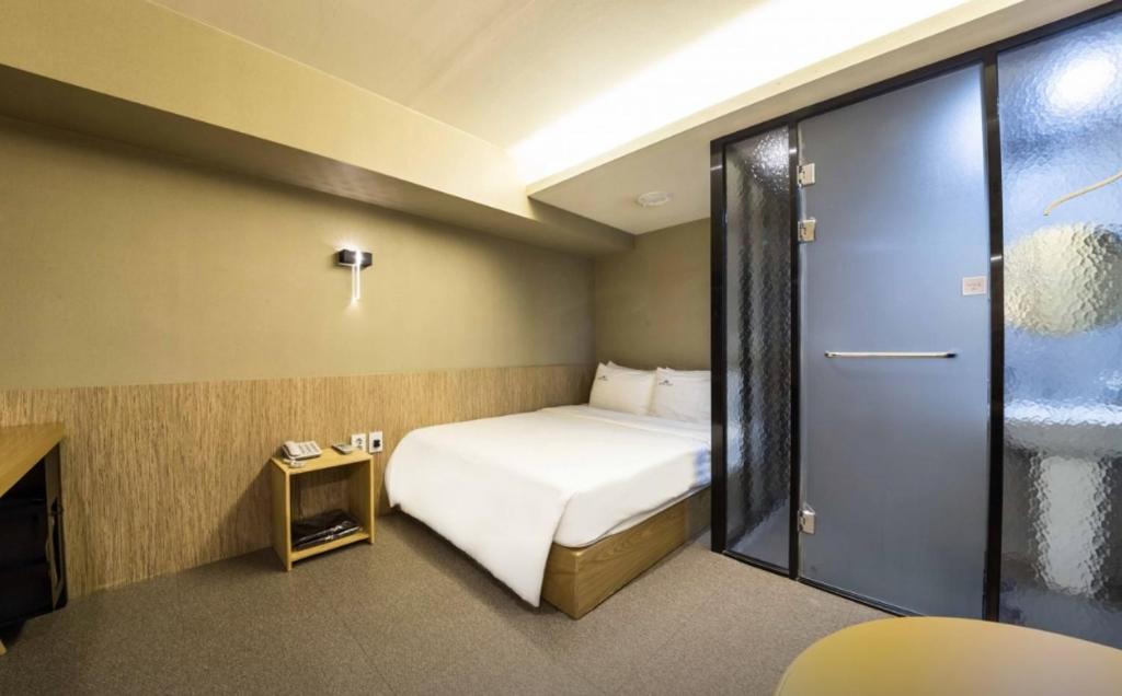 a hotel room with a bed and a sliding glass door at Hotel Daisy in Seoul