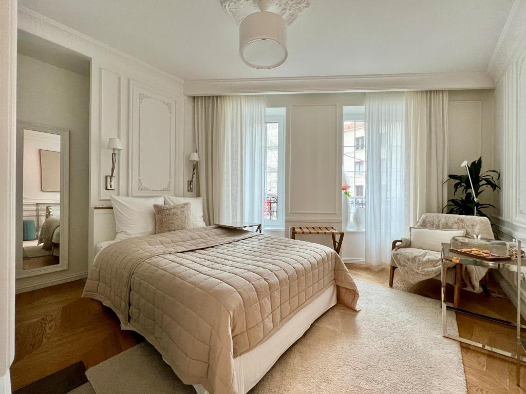 a bedroom with a bed and a chair and a mirror at Hotel Particulier La Defense - Boutique Hotel Paris in Puteaux