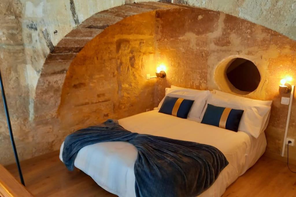 a bedroom with a bed in a stone wall at Ambre...La perle rare in Montpellier
