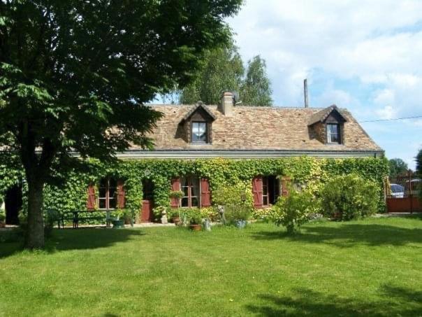 ein von Efeu bedecktes Haus in einem Hof in der Unterkunft Cottage proche circuit 24 Heures Le Mans proche de Paris Jeux olympiques autoroute à 5km in La Chapelle-Saint-Rémy