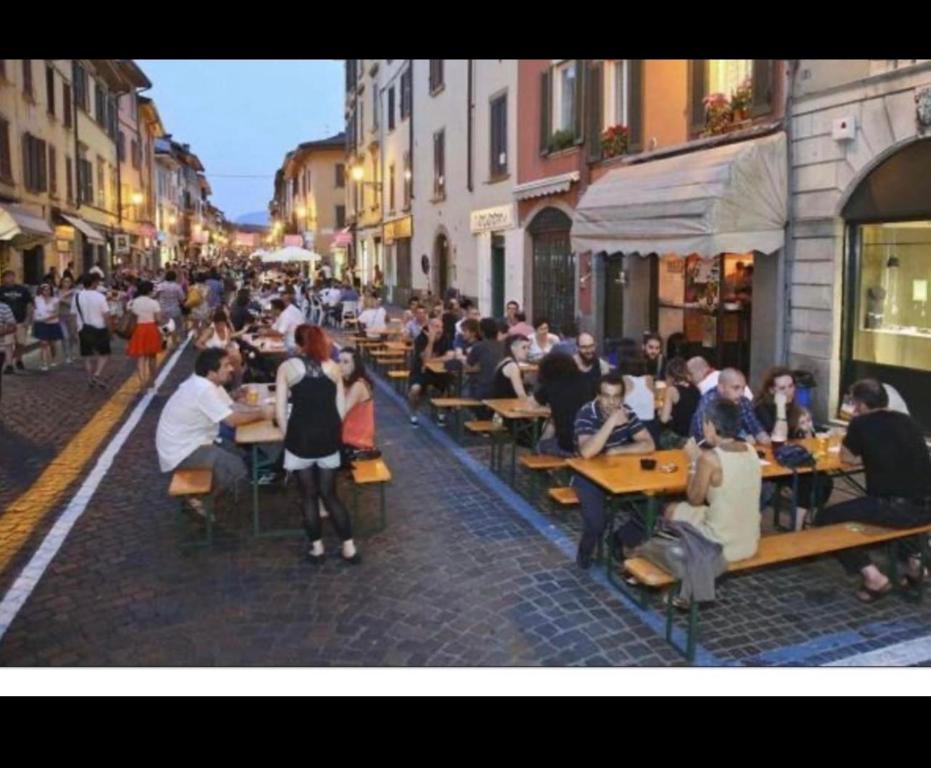 grupa ludzi siedzących przy stołach na ulicy w obiekcie Smart Silver Apartment Central w Bergamo