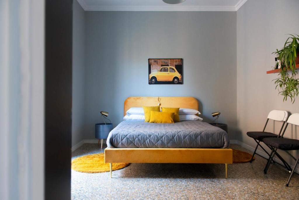 1 dormitorio con cama amarilla y pared azul en Myway RDR Apartment, en Roma