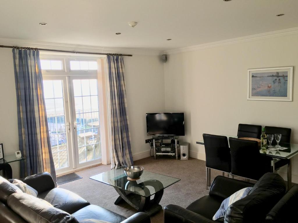 a living room with a couch and a tv at Southover Beach in Woolacombe
