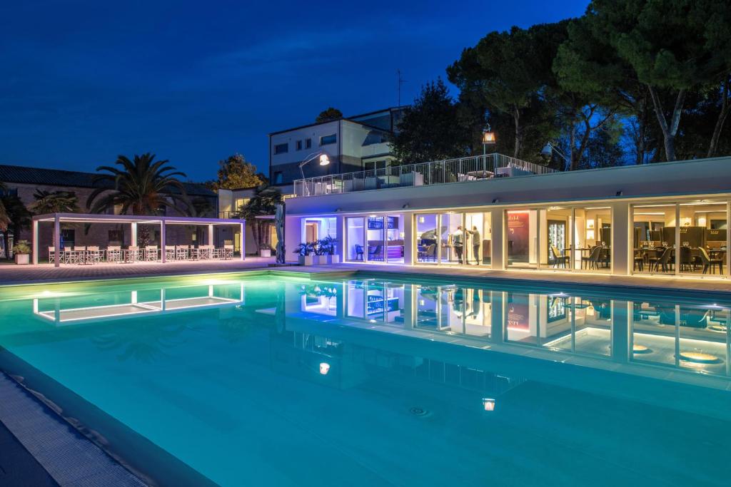 a swimming pool in front of a house at night at Finis Africae Hotel in Senigallia