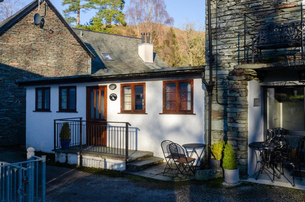 a white house with a porch with chairs and a table at Bens Cottage in Chapel Stile