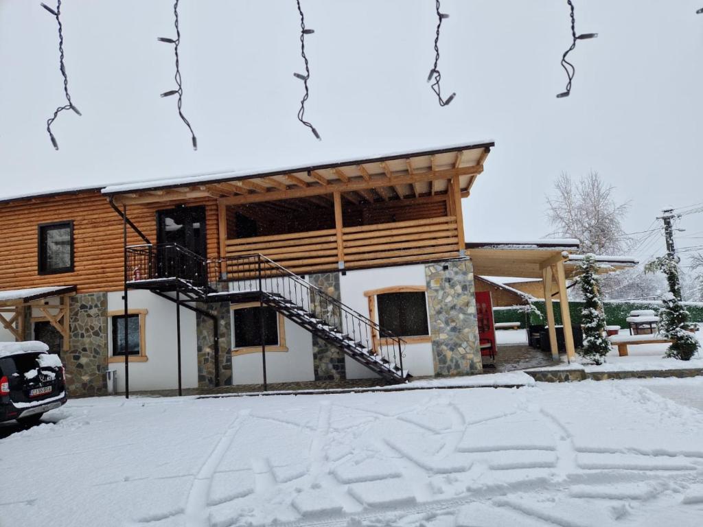 a house with a staircase in the snow at CASA DE VACANTA CLARA MARIA in Comarnic