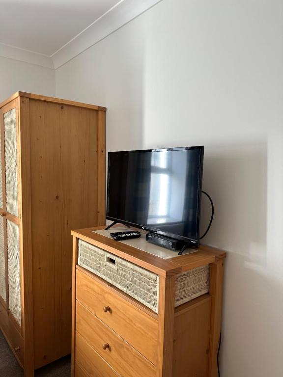 a flat screen tv sitting on top of a wooden dresser at Southover Beach in Woolacombe