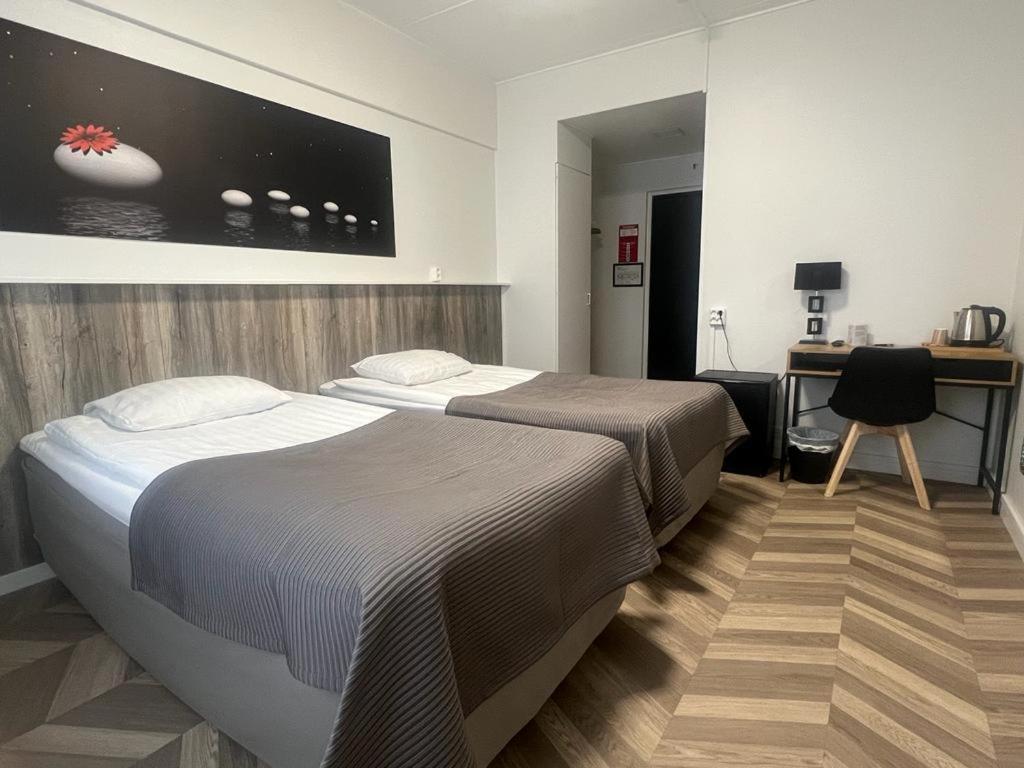 ポリにあるHotel Amadoのベッド2台とデスクが備わるホテルルームです。