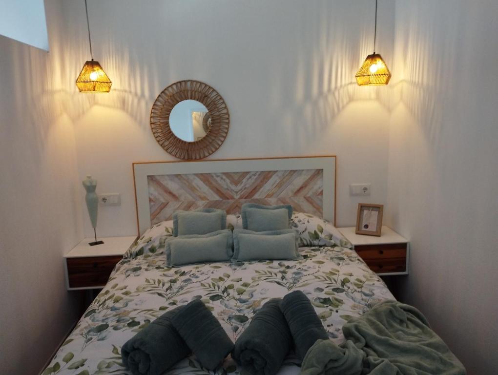 a bedroom with a bed with blue pillows and a mirror at BellAltea in Altea