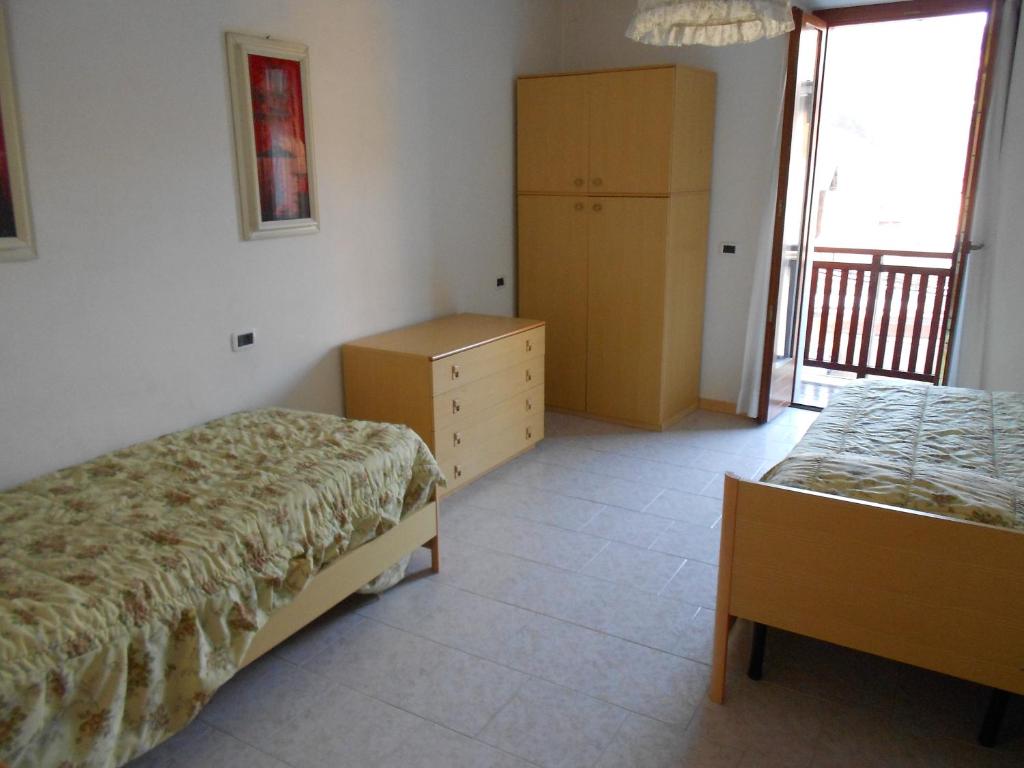 Tiarno di SopraにあるCasa Toniaのベッドルーム1室(ベッド2台、ドレッサー、窓付)