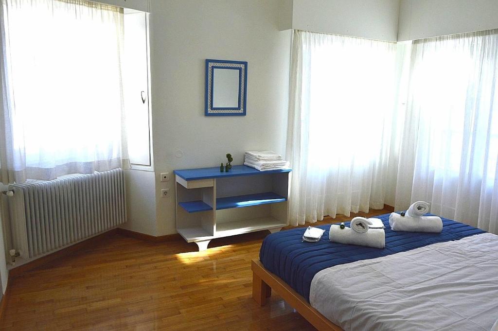 ein Schlafzimmer mit einem Bett und einer Kommode mit Handtüchern darauf in der Unterkunft EstellApartments in Athen