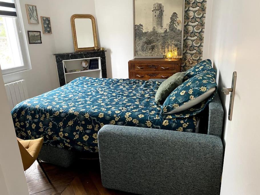 studio le 17 près de Paris في مونتلهيري: غرفة نوم بسرير وبطانية زرقاء وكرسي