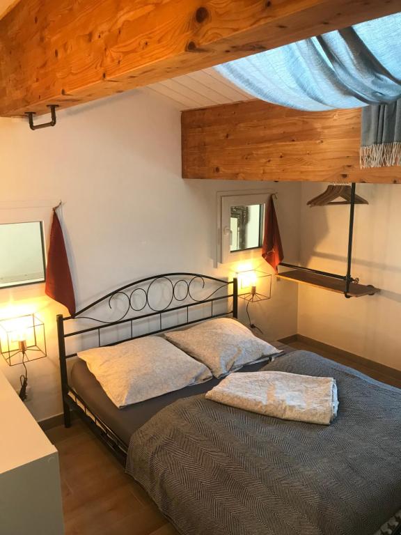 two beds in a bedroom with a wooden ceiling at Les Agapanthes in Noirmoutier-en-l'lle