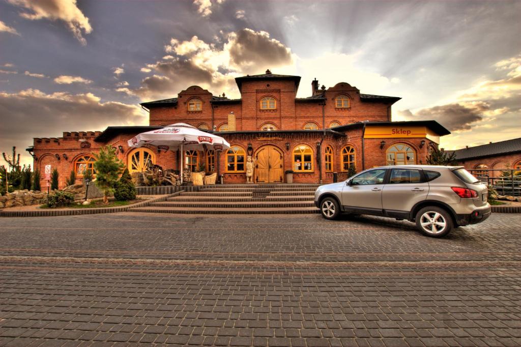 a car parked in front of a large building at Hotel Staropolska in Tomaszów Lubelski