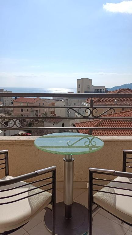 a table on a balcony with a view of a city at Nossa Casa in Bečići